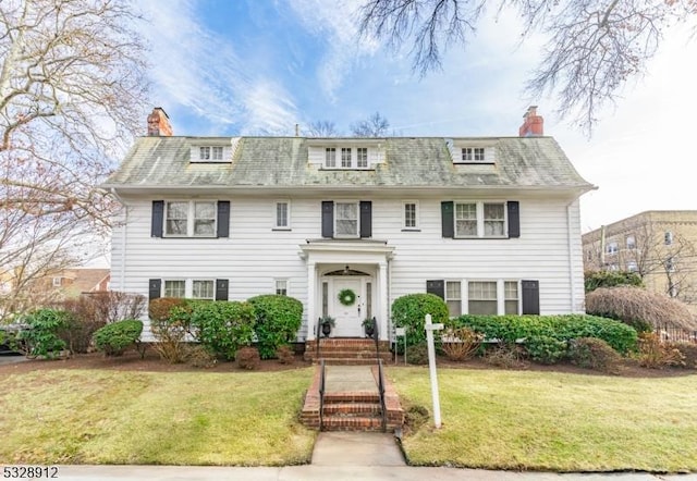 view of front of home with a front yard and a chimney