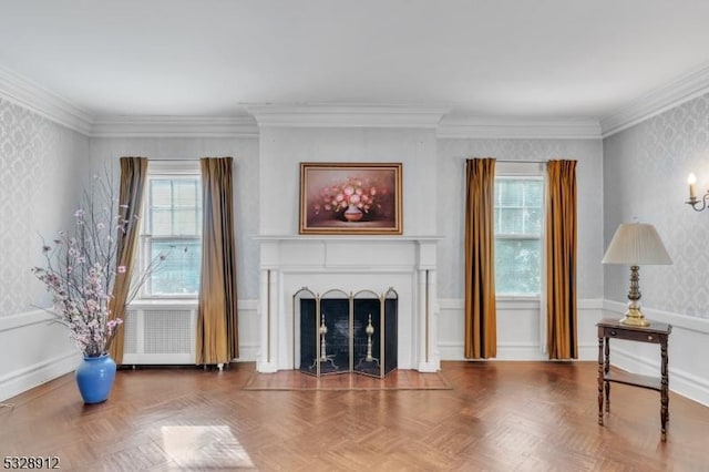 living area featuring wallpapered walls, a fireplace, a wainscoted wall, and a wealth of natural light