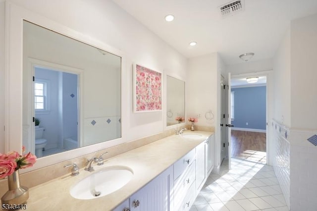 full bathroom with visible vents, toilet, a sink, tile patterned flooring, and double vanity