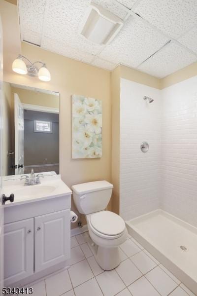 full bathroom with tiled shower, toilet, vanity, and tile patterned flooring