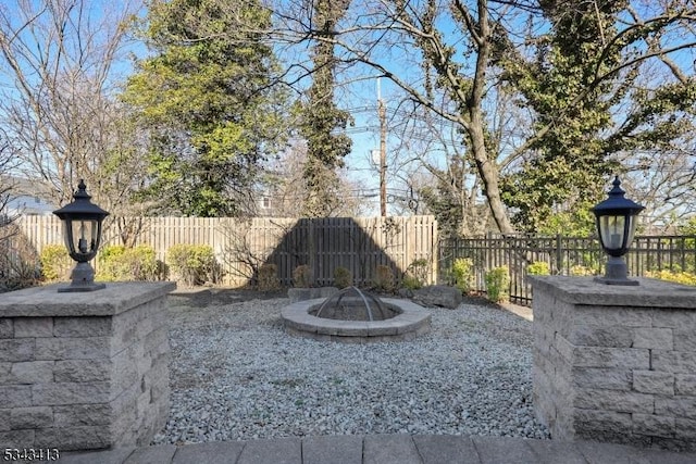 view of yard with a fire pit and fence