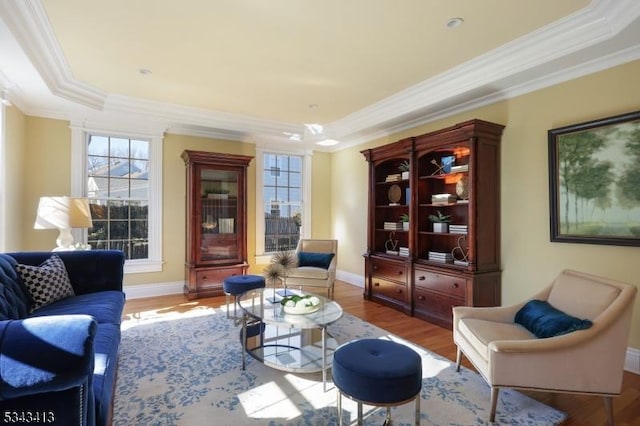 living room with baseboards, wood finished floors, and crown molding