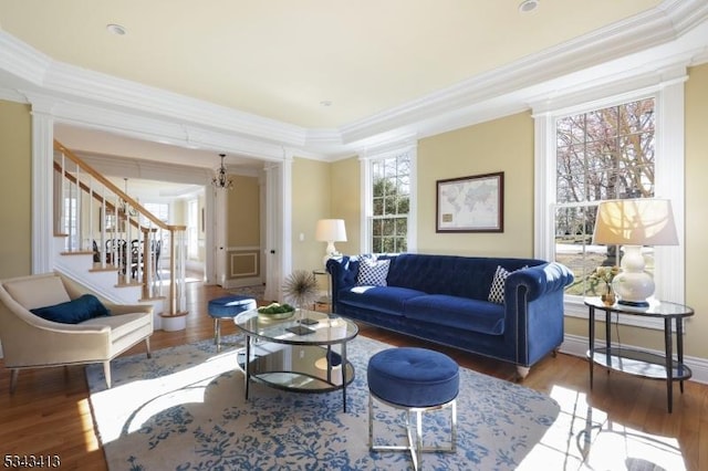 living area featuring crown molding, stairs, and wood finished floors