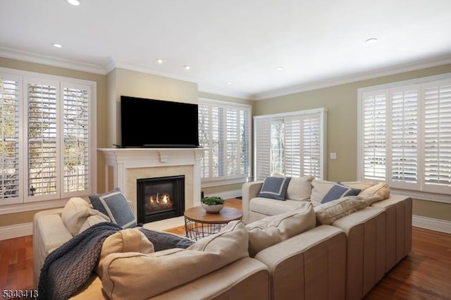 living area with a high end fireplace, crown molding, baseboards, and wood finished floors