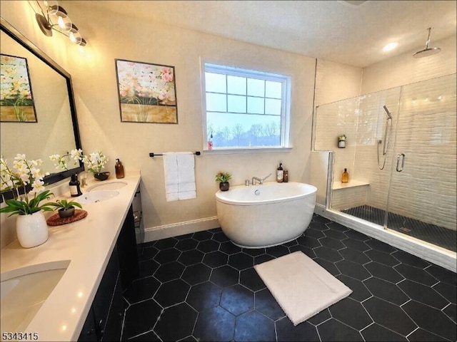 full bath featuring a sink, a shower stall, tile patterned flooring, double vanity, and a freestanding bath