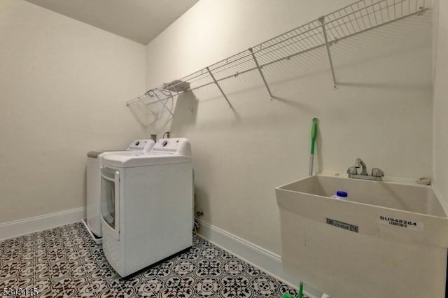 laundry area with light tile patterned floors, baseboards, independent washer and dryer, and laundry area