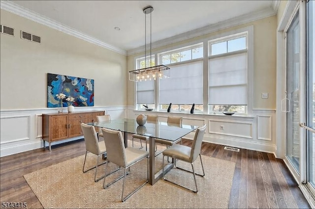 dining room with visible vents, ornamental molding, and dark wood-style flooring