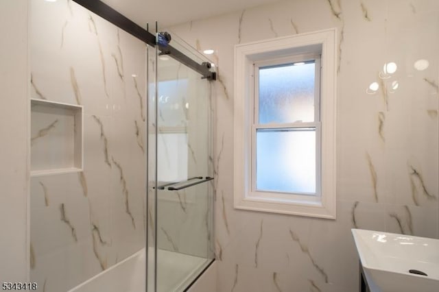 bathroom with a marble finish shower and vanity