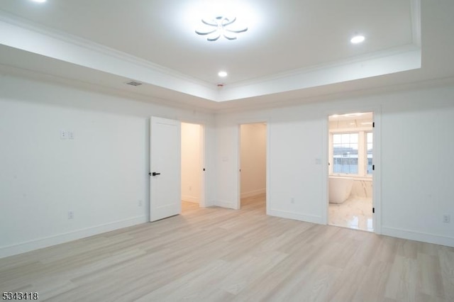 unfurnished bedroom with light wood-type flooring, a raised ceiling, baseboards, and ornamental molding