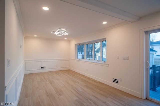 empty room with light wood finished floors, visible vents, recessed lighting, and ornamental molding