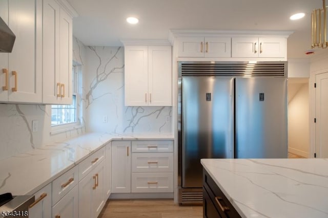 kitchen with recessed lighting, light wood-style flooring, white cabinetry, and built in fridge