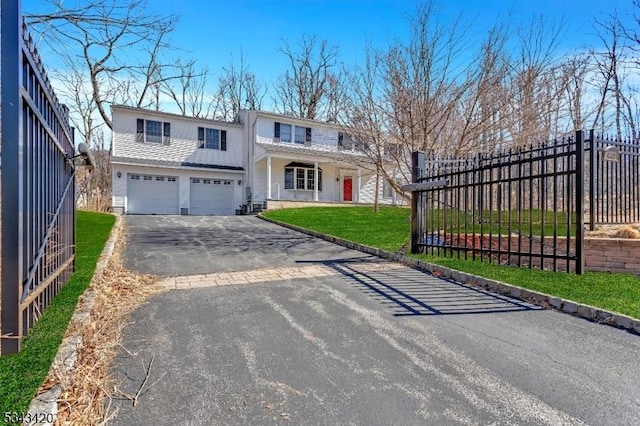 traditional home featuring a front yard, fence, driveway, roof with shingles, and an attached garage