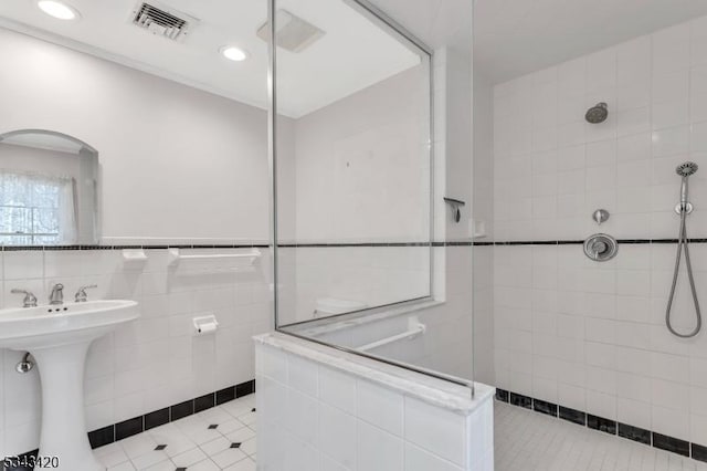 full bath featuring recessed lighting, visible vents, tile walls, and walk in shower