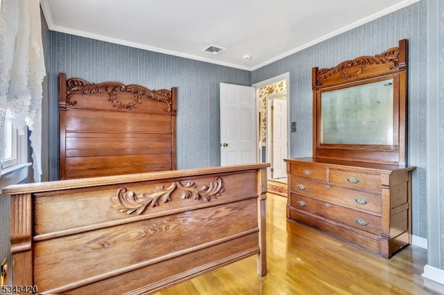 bedroom with wallpapered walls, crown molding, wood finished floors, and visible vents