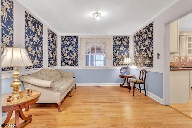 sitting room featuring baseboards and light wood-style floors