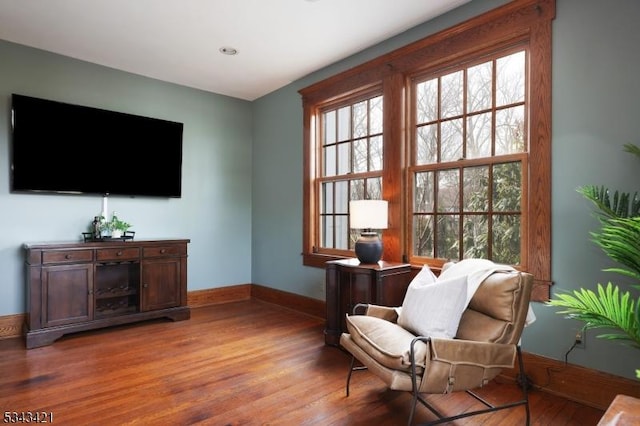 living area with wood finished floors and baseboards