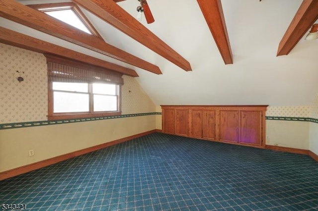 bonus room featuring lofted ceiling with beams, baseboards, dark carpet, and ceiling fan