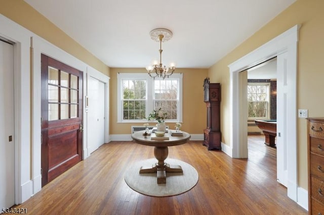 foyer featuring a wealth of natural light, pool table, light wood-type flooring, and an inviting chandelier