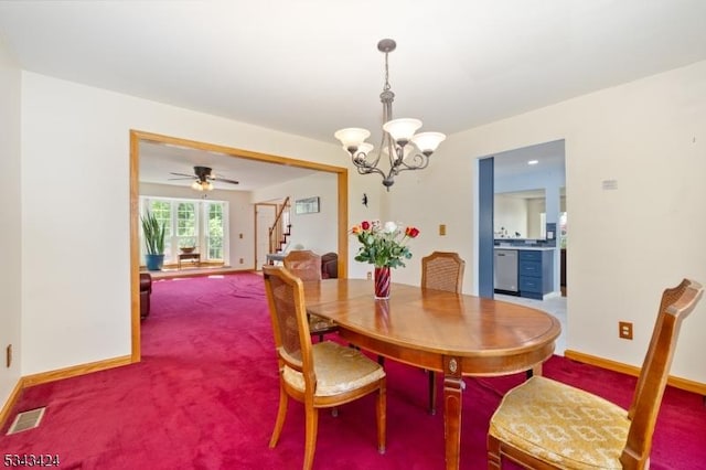 carpeted dining area with a chandelier, stairway, baseboards, and ceiling fan