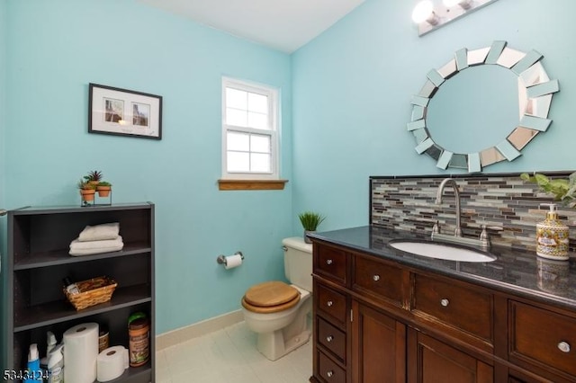 half bath featuring tasteful backsplash, toilet, vanity, and baseboards