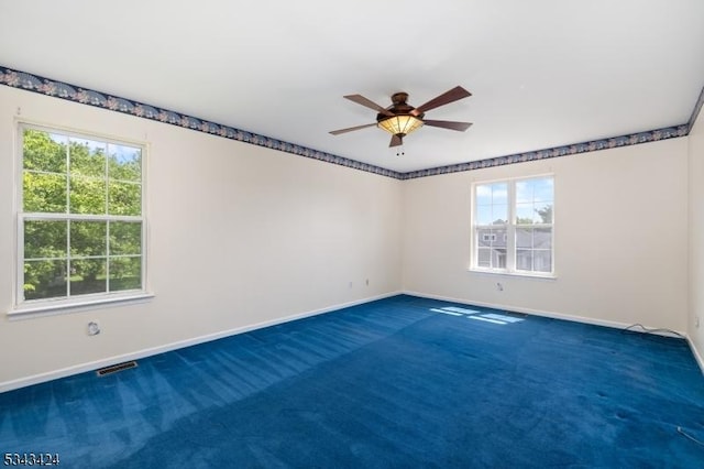 empty room with baseboards, a ceiling fan, and carpet