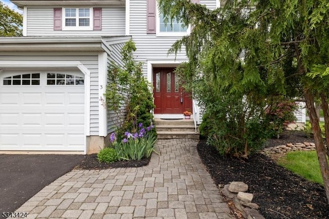 view of front of home featuring an attached garage and asphalt driveway