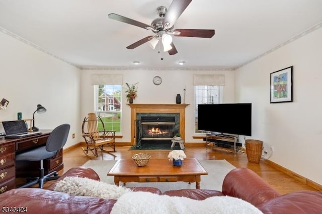 living area with plenty of natural light, a premium fireplace, baseboards, and ornamental molding