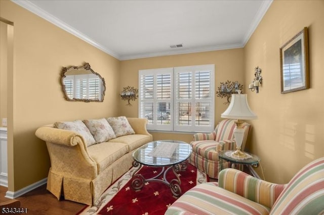 living room with visible vents, wood finished floors, baseboards, and ornamental molding