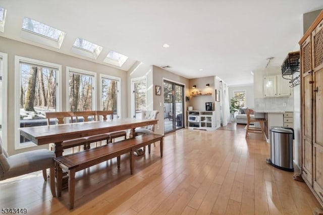 dining space with visible vents, recessed lighting, a skylight, and light wood-style floors