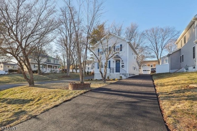 view of front facade featuring a front lawn, a garage, and a residential view