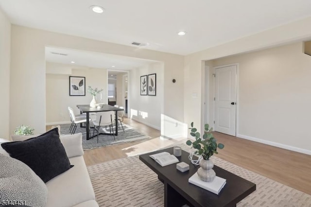 living area featuring recessed lighting, light wood-type flooring, and baseboards