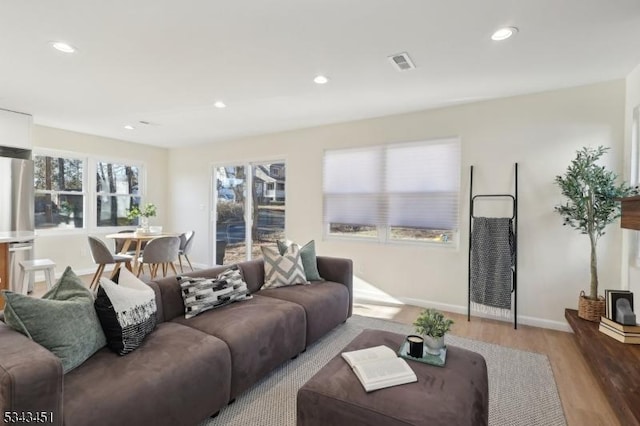 living area with visible vents, recessed lighting, baseboards, and light wood-style floors