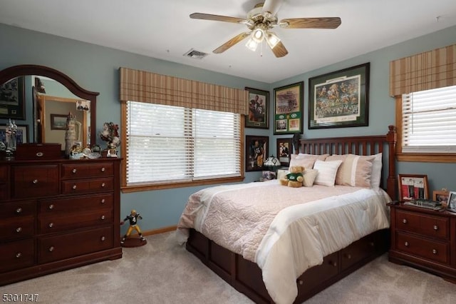 carpeted bedroom featuring visible vents, baseboards, and a ceiling fan