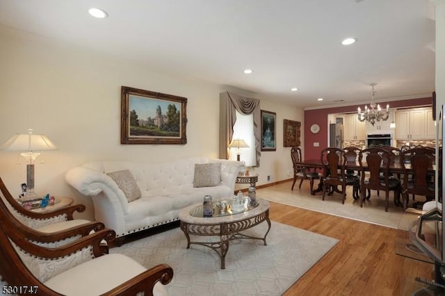 living room featuring recessed lighting, light wood-style floors, and a notable chandelier