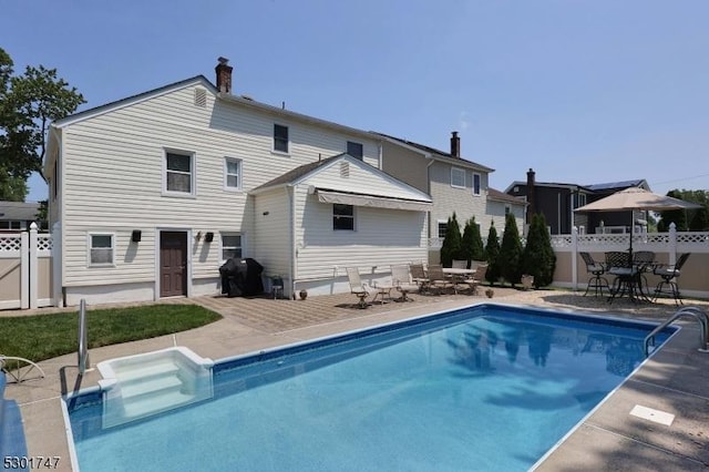 rear view of property with a patio area, outdoor dining space, a fenced in pool, and fence