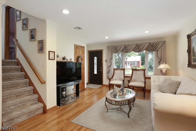 living area with visible vents, recessed lighting, crown molding, light wood finished floors, and stairs