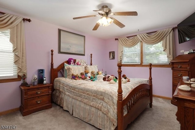 bedroom featuring light colored carpet, baseboards, and ceiling fan