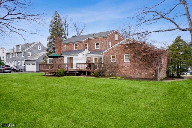 rear view of house featuring brick siding, a lawn, a deck, and a chimney