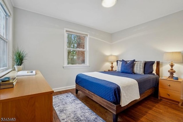 bedroom featuring baseboards and dark wood-style flooring