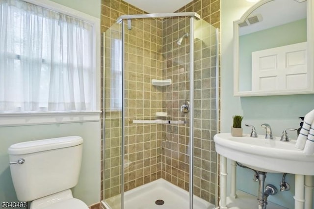 bathroom featuring visible vents, plenty of natural light, toilet, and a stall shower