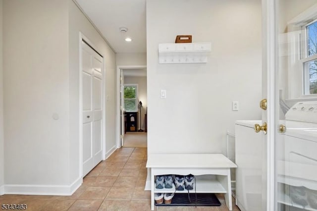 interior space featuring baseboards, washer / dryer, and light tile patterned flooring