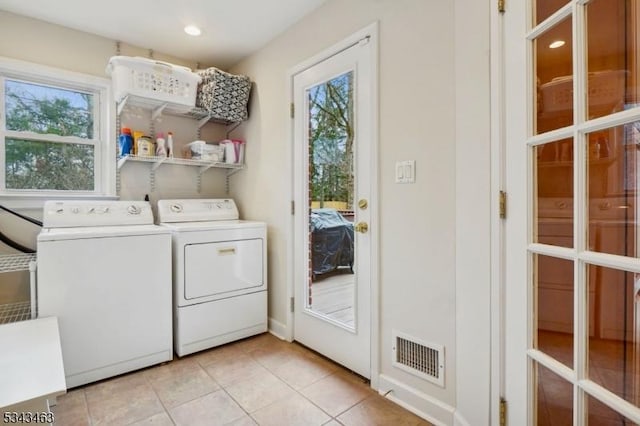 washroom with visible vents, plenty of natural light, laundry area, and washing machine and clothes dryer