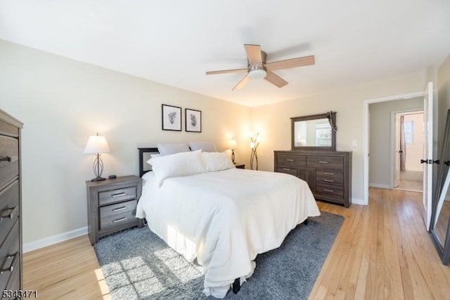 bedroom with light wood finished floors, ceiling fan, and baseboards