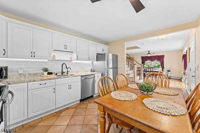 106 Chincopee Ave, Hopatcong Boro, NJ 07843 - kitchen featuring stainless steel appliances, a ceiling fan, white cabinetry, decorative backsplash, and light stone counters
