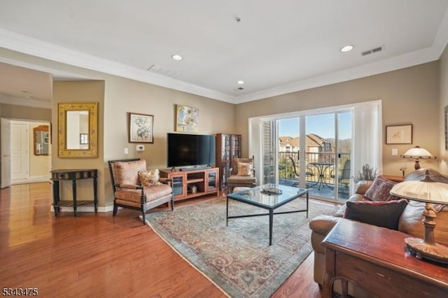 living room featuring recessed lighting, visible vents, ornamental molding, and wood finished floors