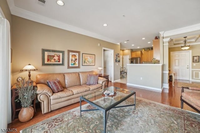 living area with recessed lighting, visible vents, wood finished floors, and ornamental molding