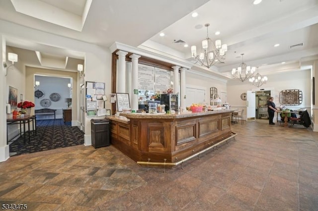 reception with visible vents, a notable chandelier, and ornate columns