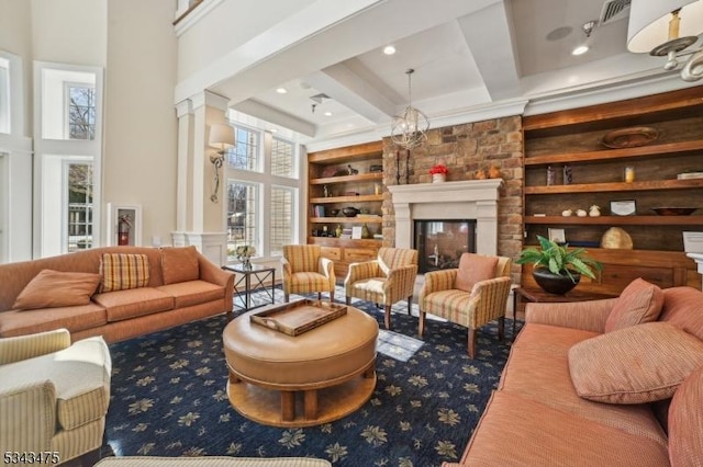 living room with visible vents, built in features, beamed ceiling, a high ceiling, and a glass covered fireplace