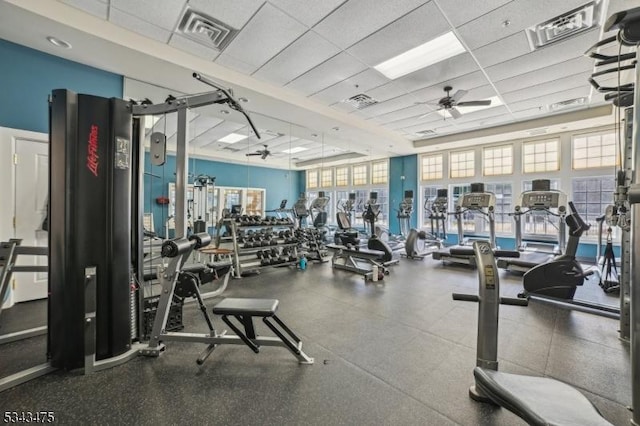 exercise room with visible vents, a drop ceiling, and ceiling fan