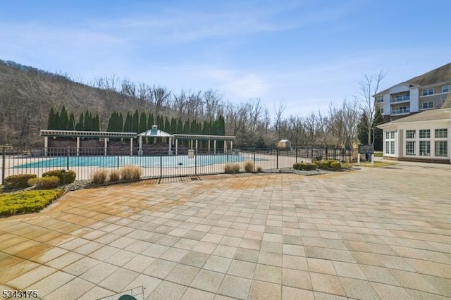 community pool featuring a patio area and fence